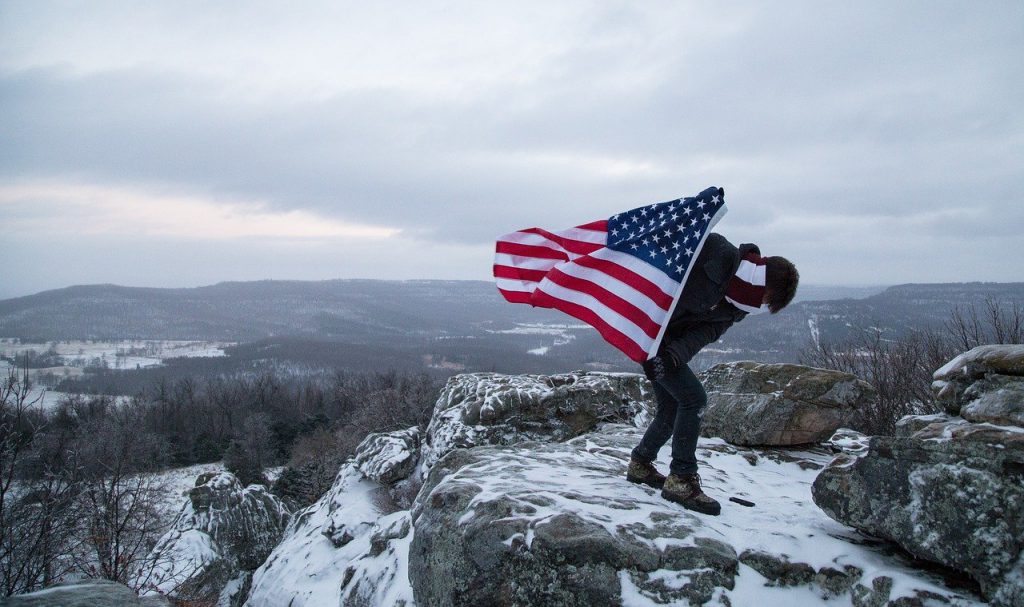 american flag, holding, mountain top